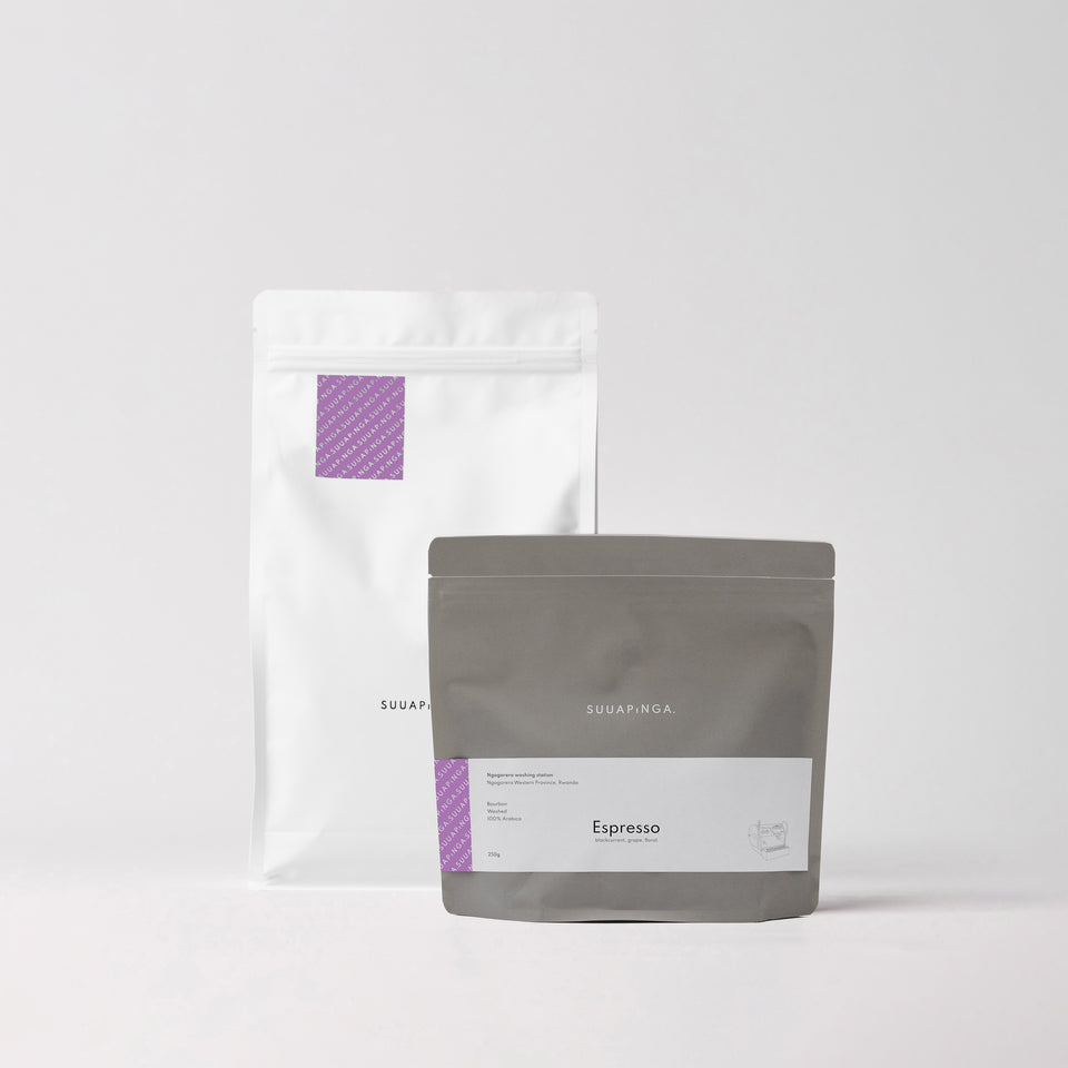 Two coffee packages, one white and one gray, with visible branding on a light gray background.